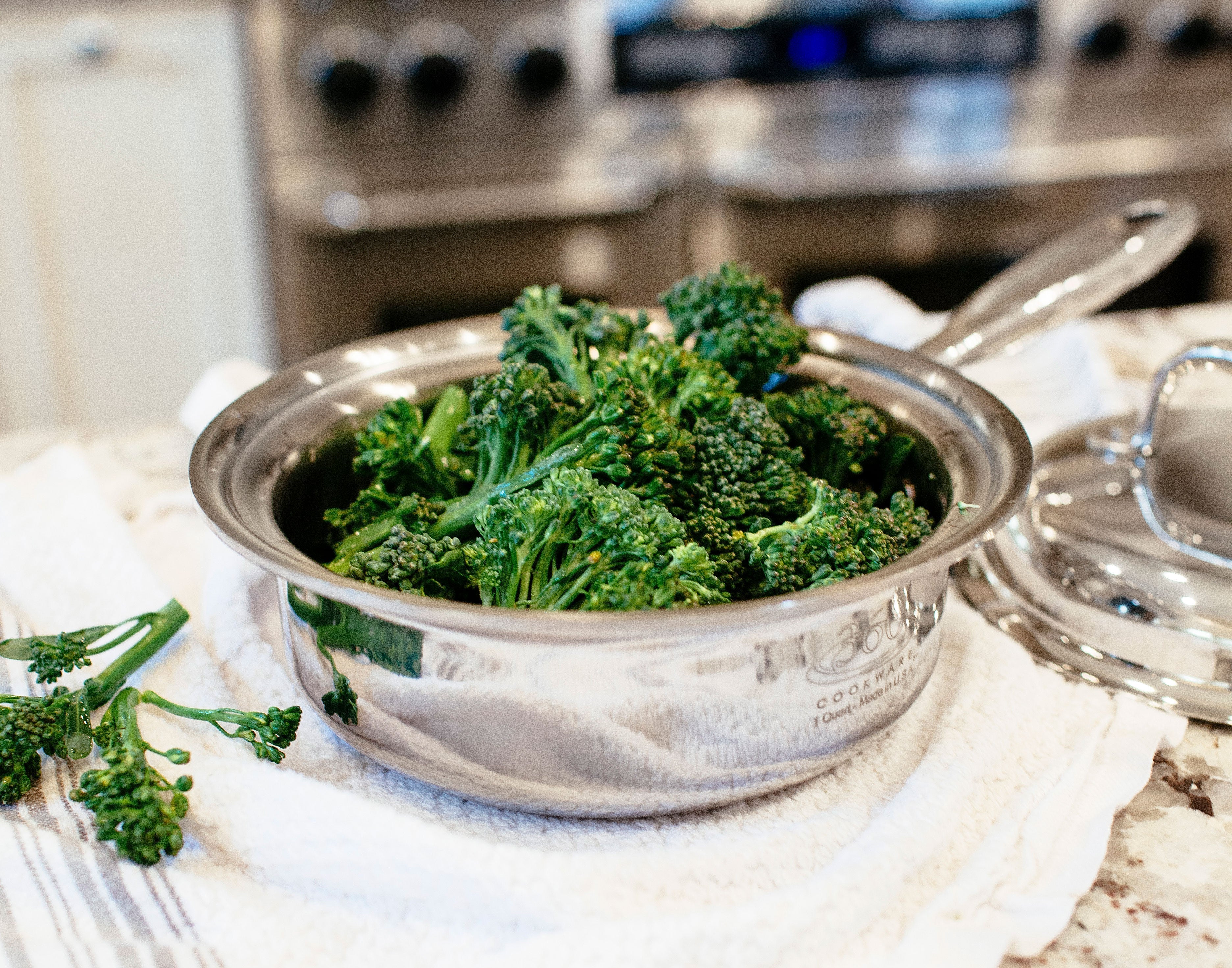 A pot of steamed broccoli on a kitchen counter