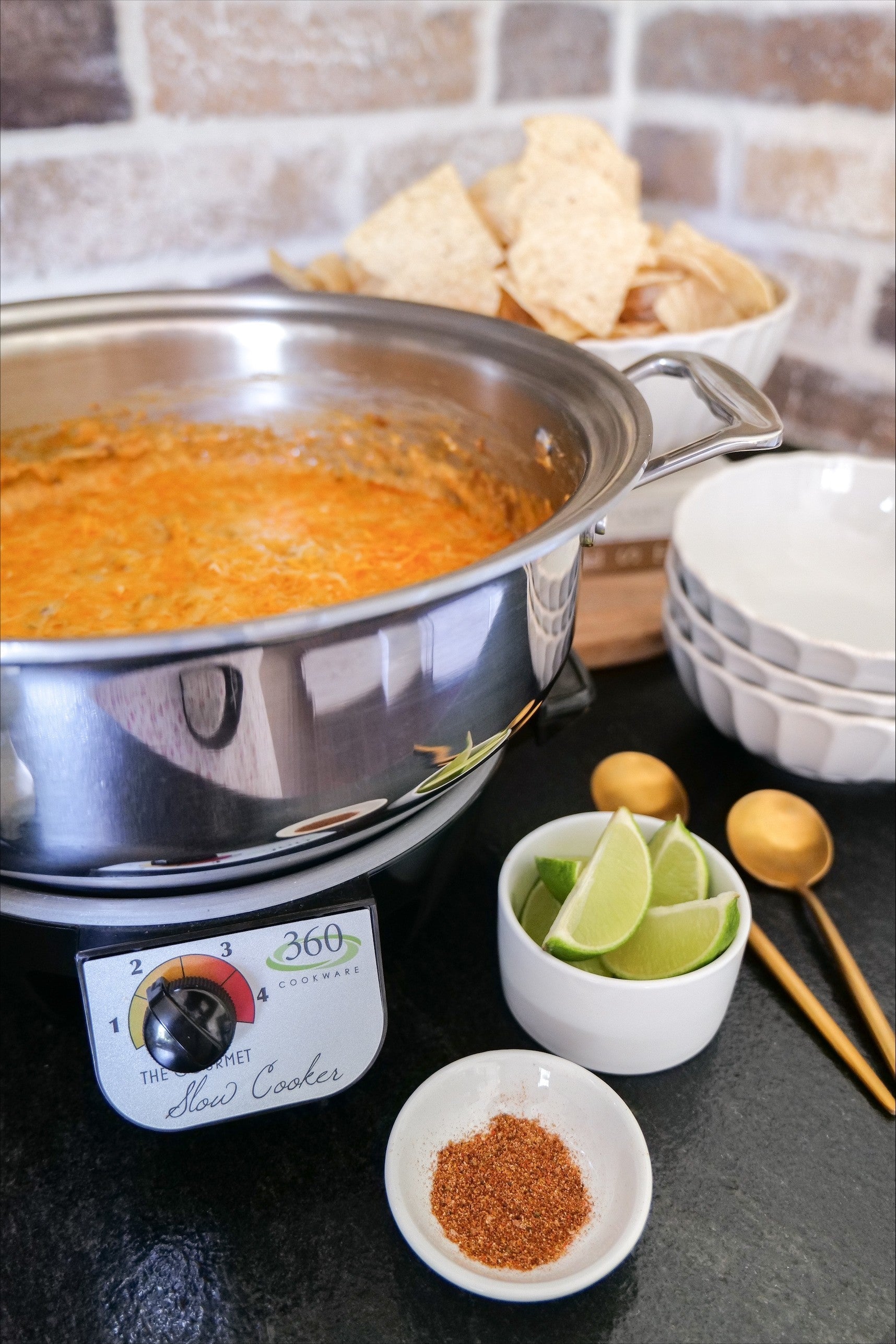 Slow Cooker Enchilada Dip with tortilla chips, lime, and spices
