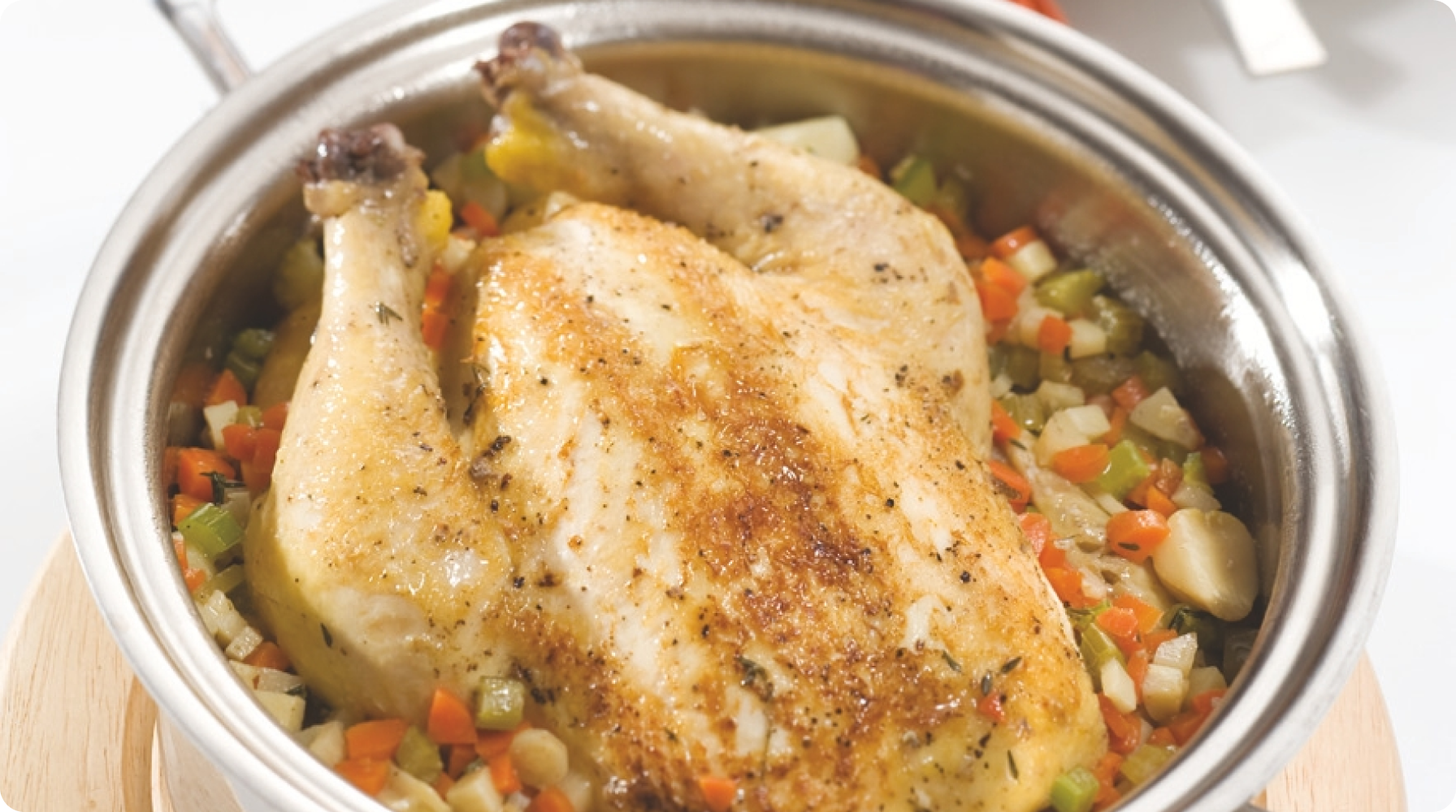 Roasted chicken on a bed of mixed vegetables in a pot