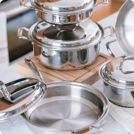 A collection of stainless steel cookware including pots and lids on a countertop.