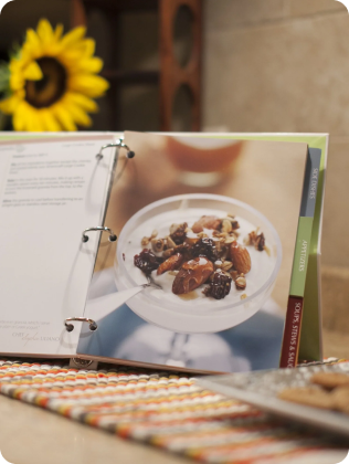 Open recipe book page showing a dessert with nuts and dried fruits, including text for ingredients and instructions.