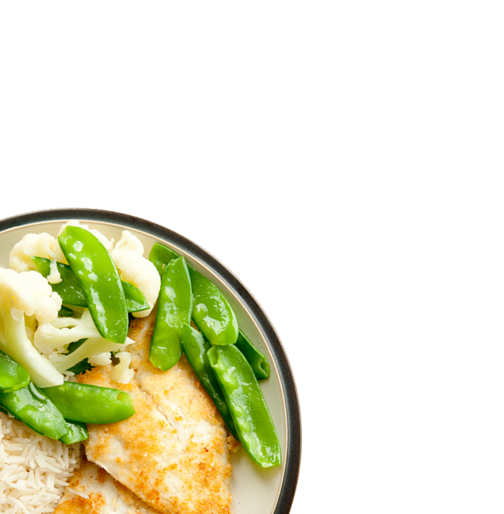 Plate with cooked fish fillet, snap peas, cauliflower, and white rice
