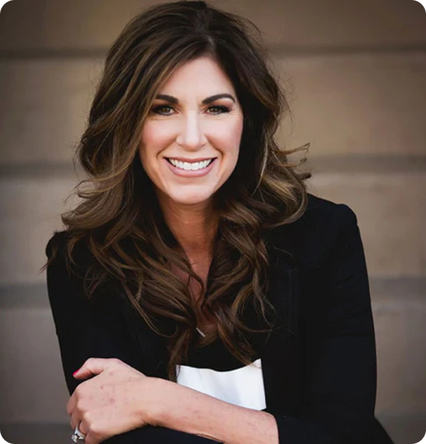 Andrea Thompson smiling, with long hair and a black blazer