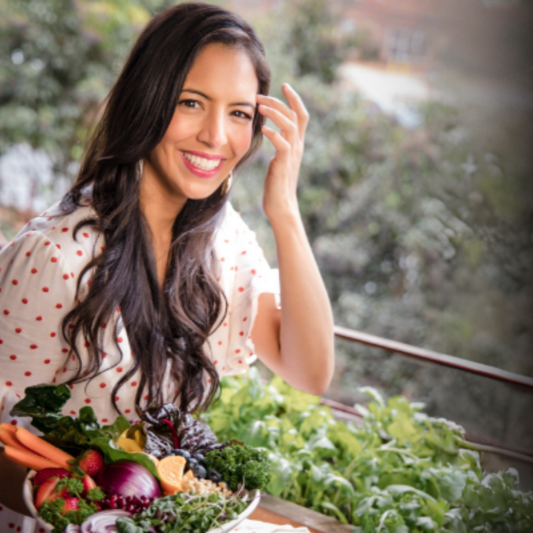 The Food Babe holding a bowl of fresh vegetables with a natural outdoor background