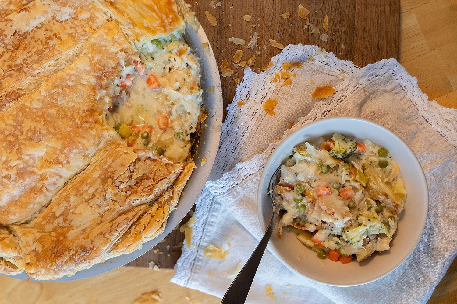 A 12" stainless steel pan with a pot pie and a serving in a bowl.