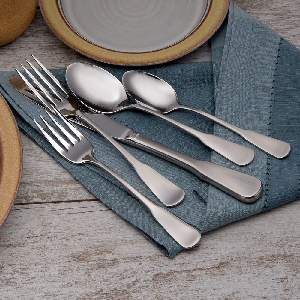 Candra 45 Piece Set flatware displayed on a blue napkin with plates