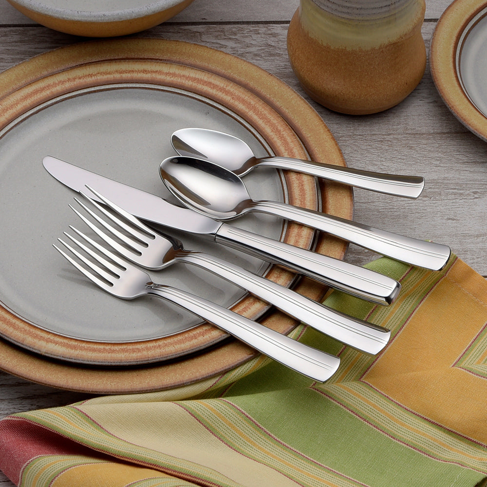 Cedarcrest 45 Piece Set flatware displayed on a table with plates and a colorful tablecloth