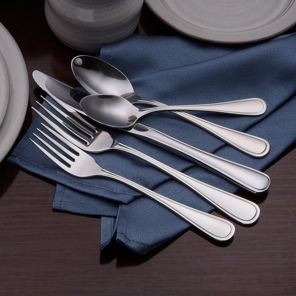 Five stainless steel utensils including a knife, spoon, and forks on a blue napkin.