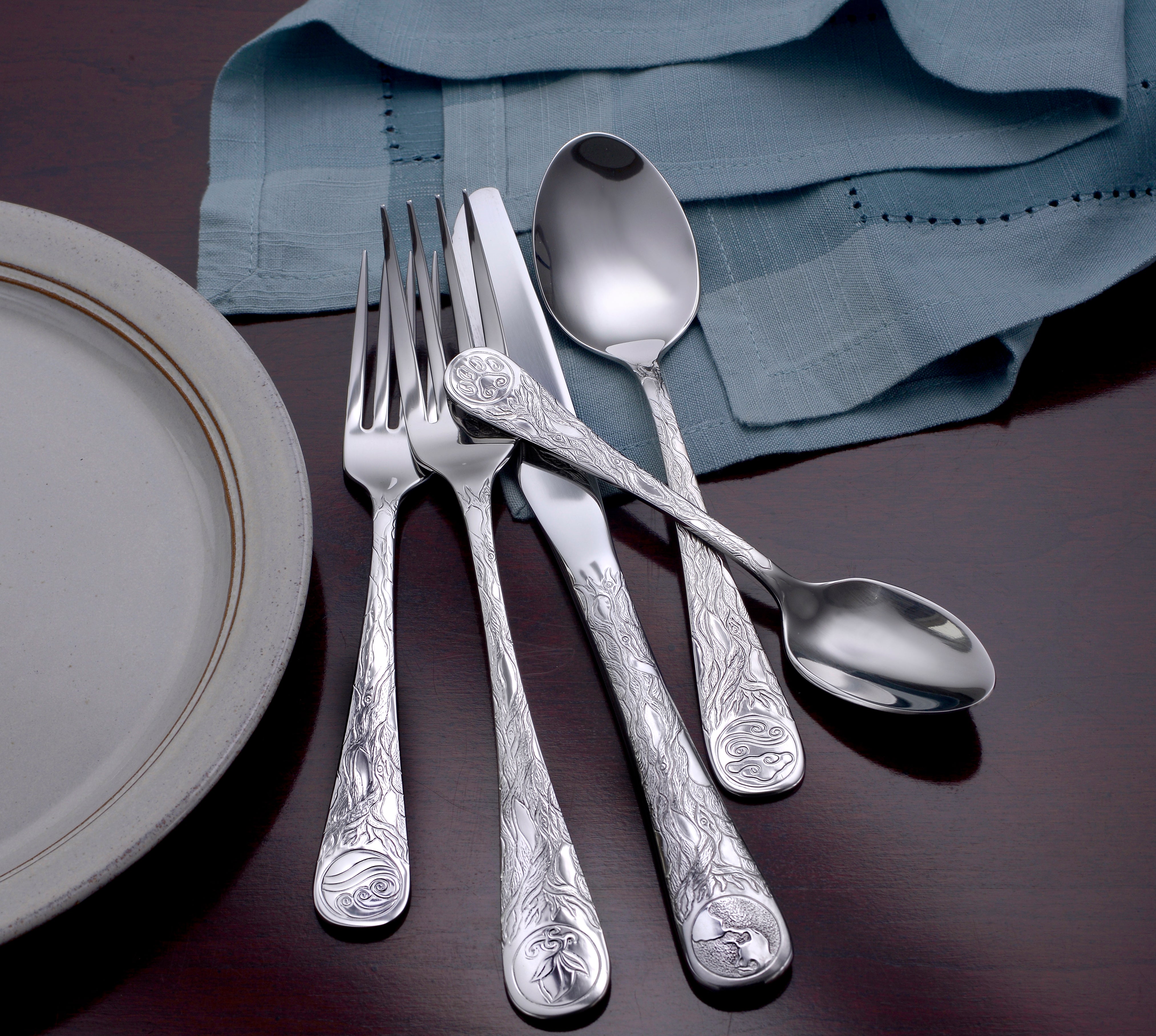 Earth Pattern Flatware set featuring eco-conscious design on a table setting with a plate and cloth