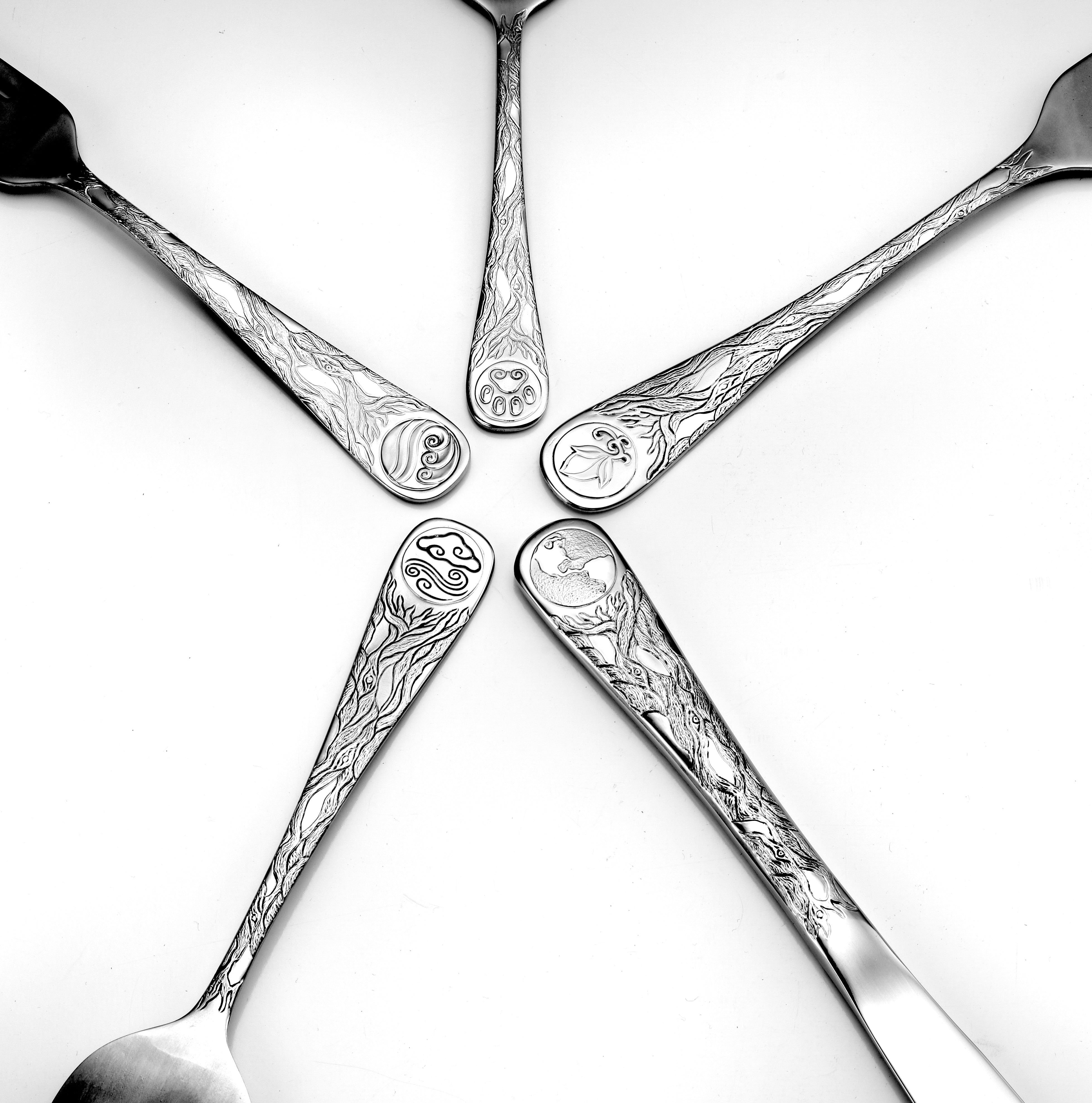 Five pieces of Earth Pattern flatware featuring eco-conscious designs with planet motifs.
