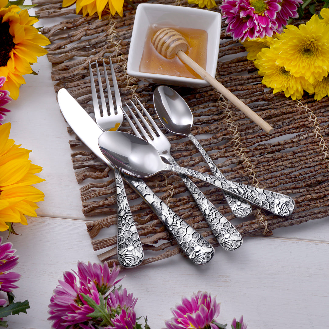 Honey Bee flatware set displayed with honey and flowers on a rustic table