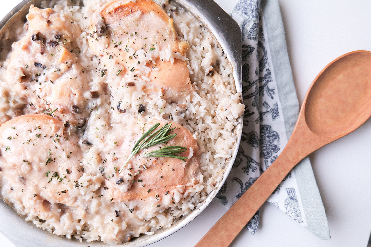 Creamy chicken and rice dish in a round pan with herbs
