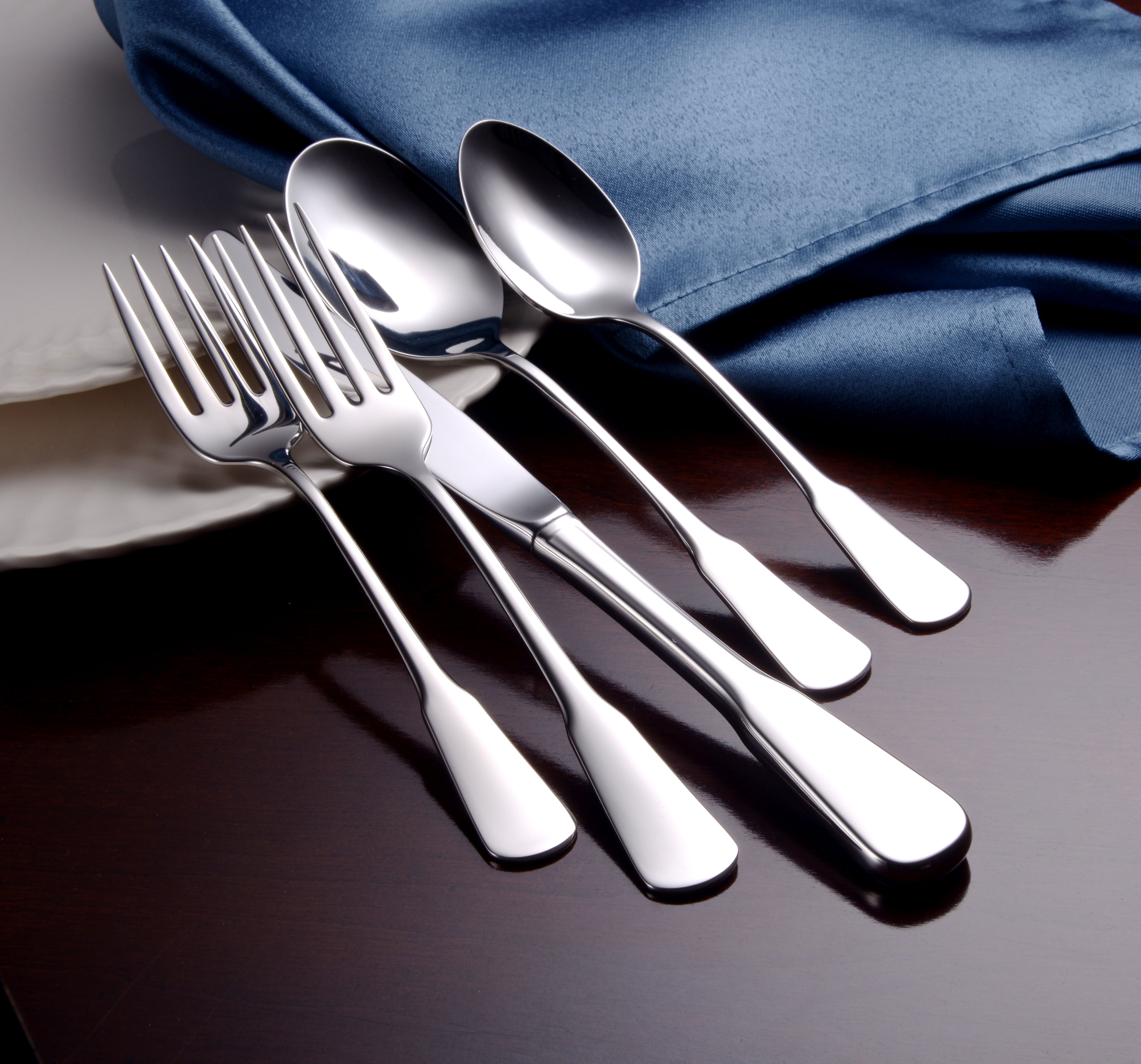 Susanna 45 Piece Set including forks, spoons, and knives on a blue cloth