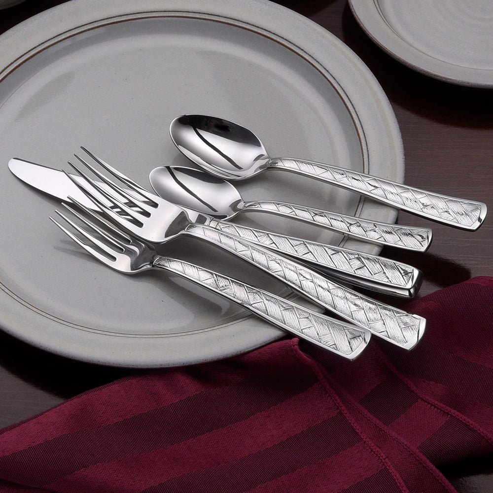 Weave 65 Piece Set including a knife, fork, and spoon on a plate with a napkin