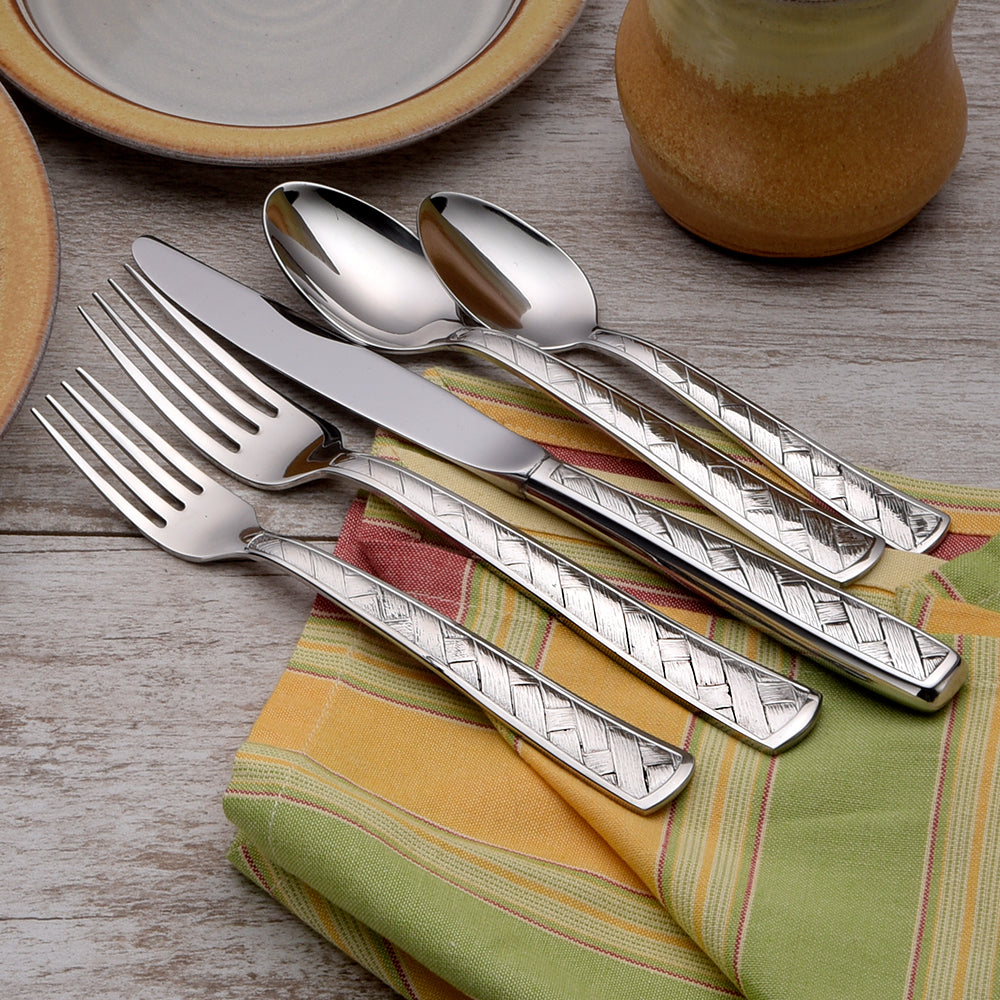 A set of five utensils including forks, knife, and spoon on a table with a striped cloth.