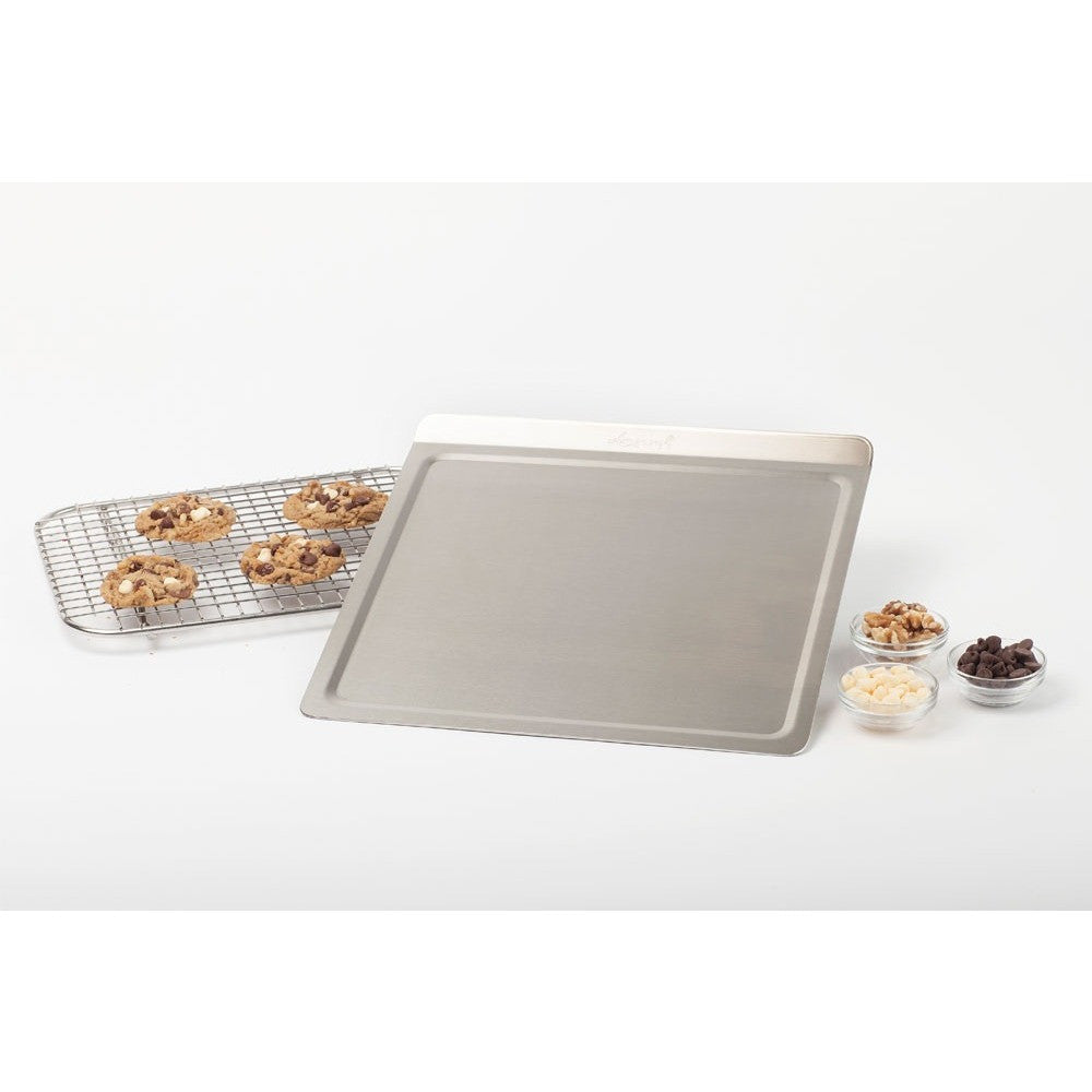 Medium stainless steel cookie sheet with cookies on a cooling rack and bowls of toppings